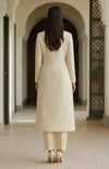 Ivory long-line kurta with straight trousers.